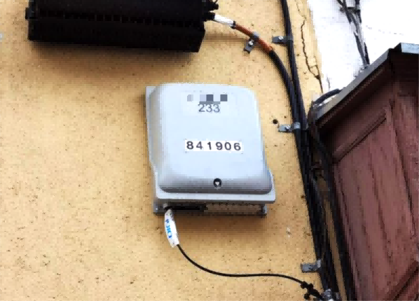 wall-mounted fiber distribution box installed on an exterior building wall for urban FTTH deployment.