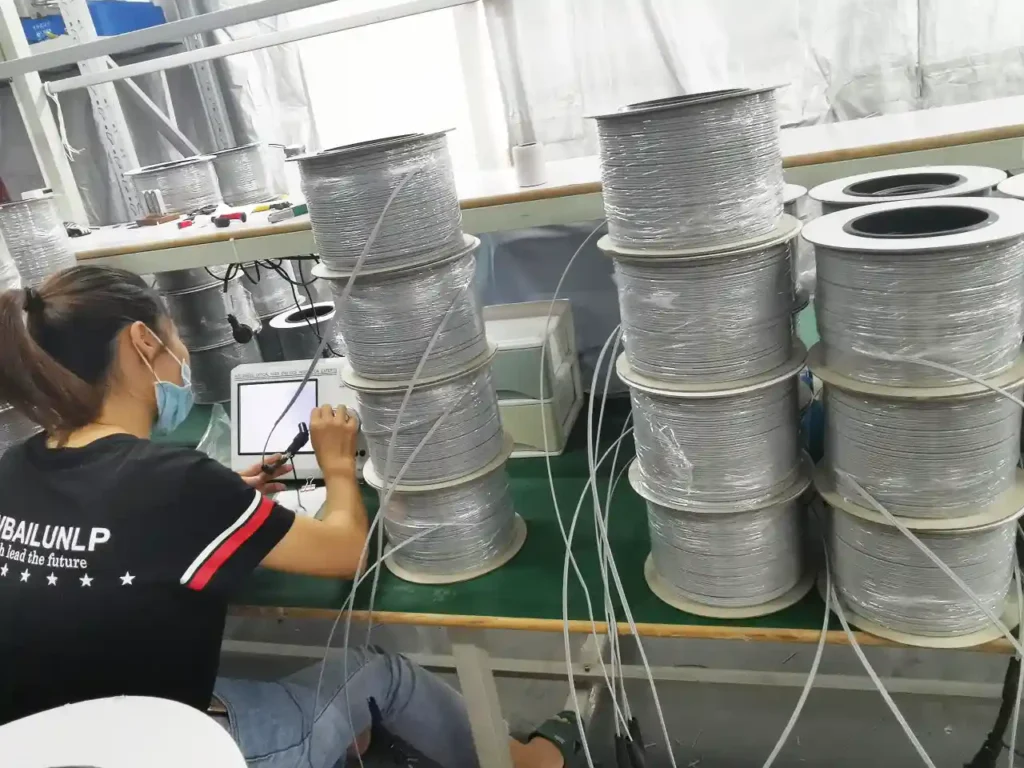 fiber optic cable quality control: technician performing end-face inspection on pre-terminated drop cables.
